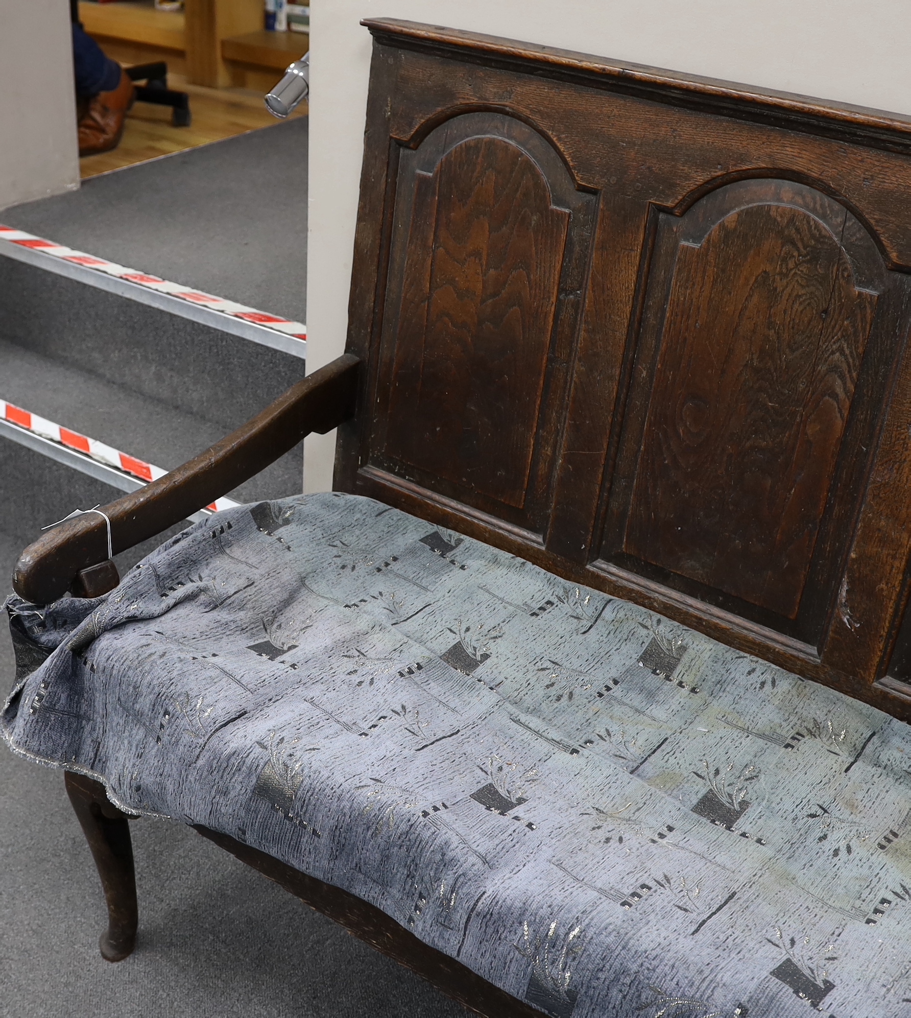 An 18th century panelled oak settle, with squab cushion seat, width 184cm, depth 65cm, height 112cm